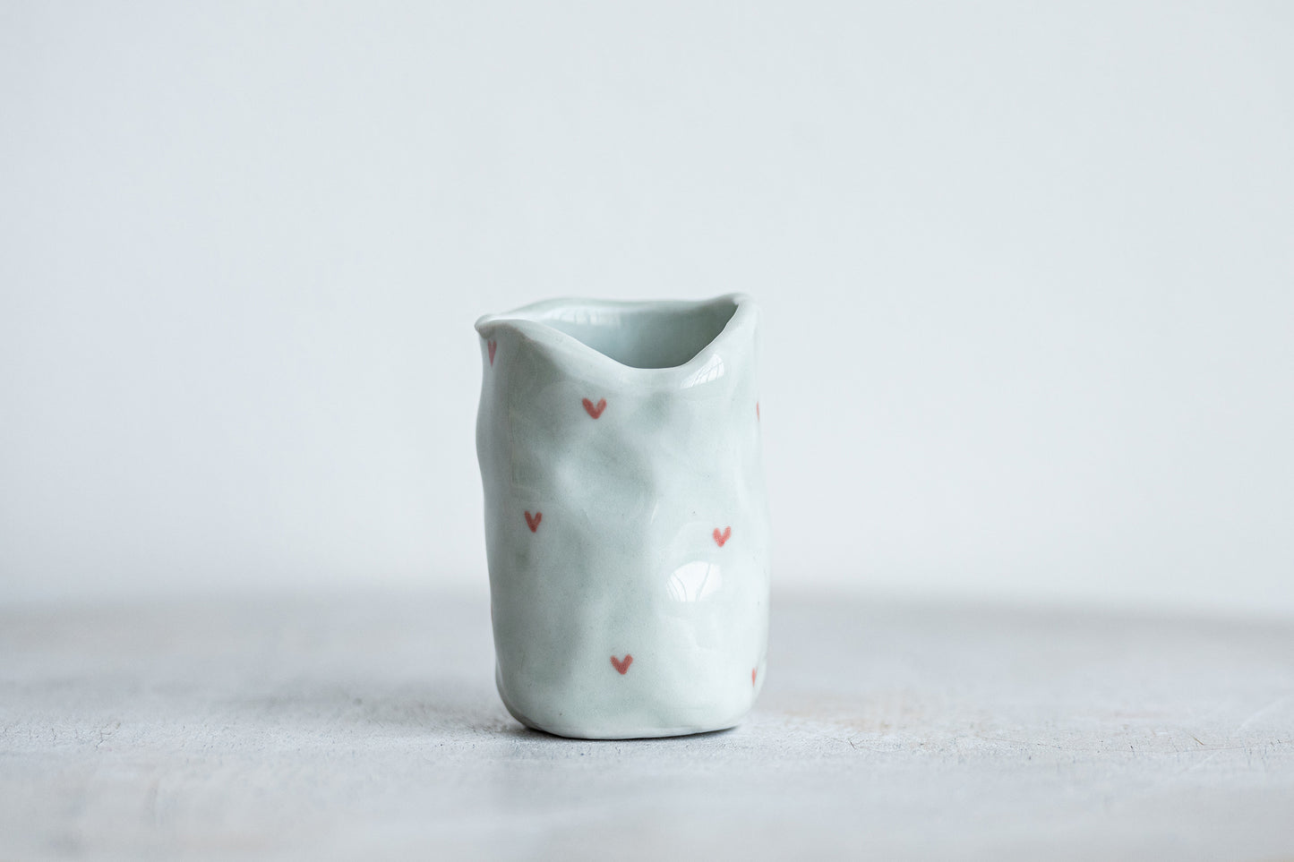 tiny porcelain pinch pot vessel with a hand painted heart design underdog